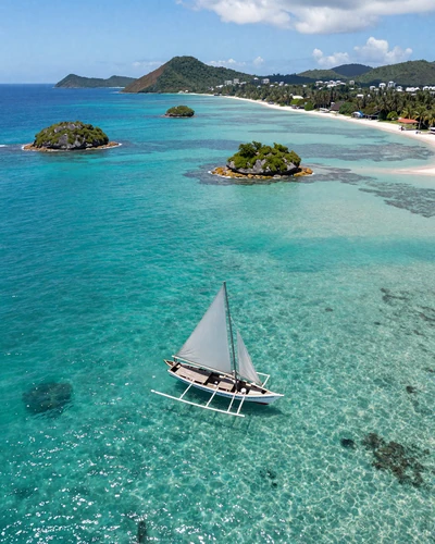 Aerial view of Tobago Cays Grenadines with turquoise water coral reefs and sailboat anchored near white sand beach